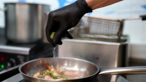 Chef squeezes fresh lime over shrimp in a pan, adding herbs while cooking seafoo Stock Footage 313882513
