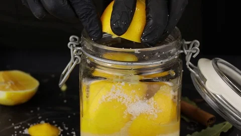 Chef squeezes juice from half a lemon Stock Footage 123116987