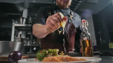 Chef squeezes juice from half a lemon with hands Stock Footage 314893273