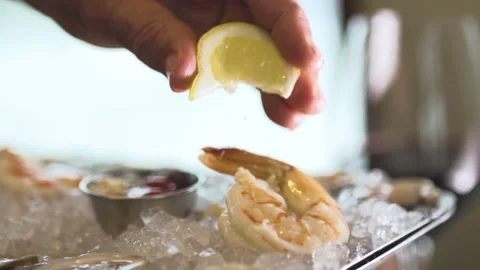 A chef squeezes lemon onto a shrimp Stock Footage 132510370
