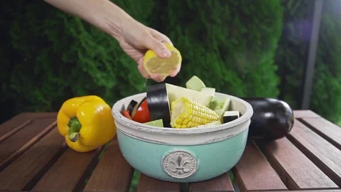 Chef squeezes out lemon juice to the bowl with fresh sliced vegetables, fruit Video stock 77548205
