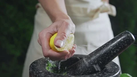 Chef squeezes out lemon juice to the bowl for cooking sauce Stock Footage 143779705