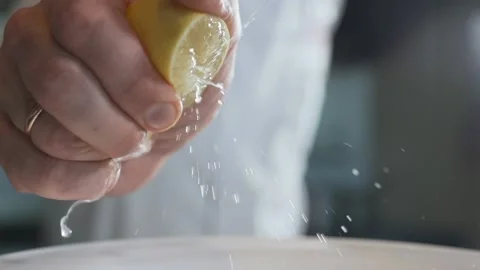 Chef squeezes out lemon juice to the bowl for cooking sauce Stock Footage 143779741