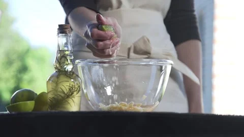 Chef squeezes out lemon juice to the bowl for cooking sauce Stock Footage 143779744