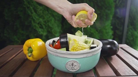 Chef squeezes out lemon juice to the bowl with fresh sliced vegetables salade Stock Footage 143779768