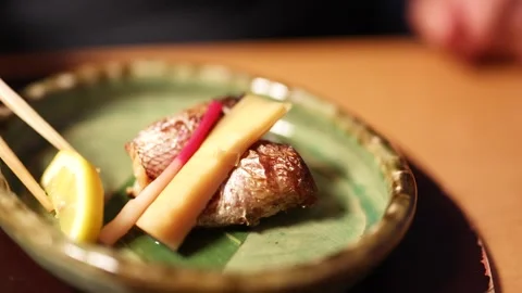Chef Squeezing Fresh Lemon Over Grilled Japanese Fish with Ginger Root Stock Footage 334827964