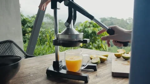 Chef squeezing fresh orange juice with manual citrus press Stock Footage 303764562