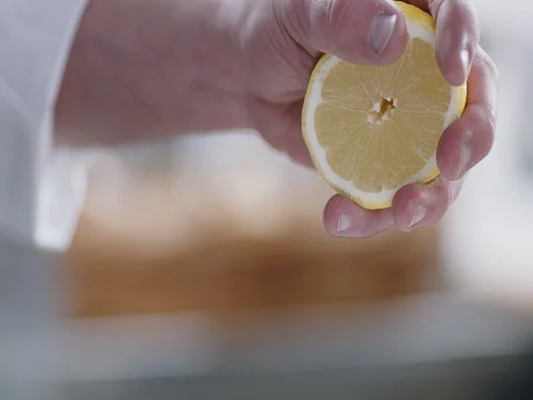 Chef is squeezing a lemon Stock Footage 78030844