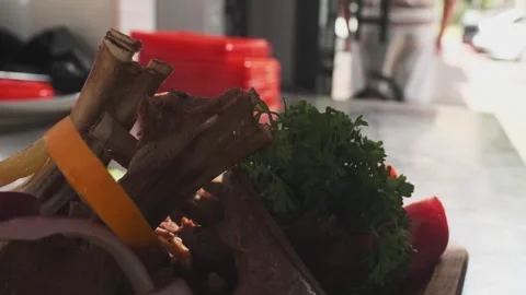 Chef squeezing lemon juice on served dish with meat, herbs, tomatoes and Stock Footage 254688279
