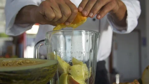 Chef squeezing orange in blender jug at kitchen Stock Footage 85814764