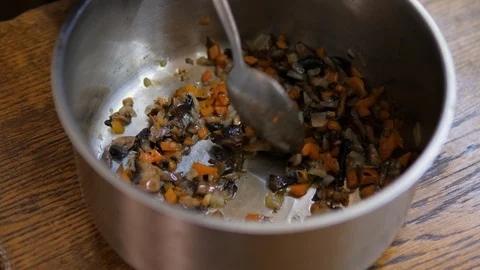 Chef stir fried vegetables in a saucepan with a spoon Stock Footage 119546784