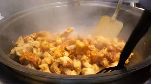Chef Stir-Frying Diced Orange Chicken in Large Commercial Wok Video stock 343027504