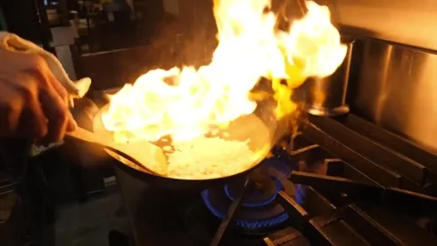 Chef Stir-Frying Rice in Wok with Large Fire Flame Flambé in Restaurant Kitchen Video stock 347688053