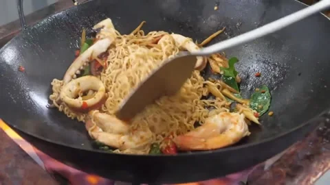 Chef Stir-Frying Spicy Thai Instant Noodles with Seafood in a Hot Wok Stock Footage 338211981