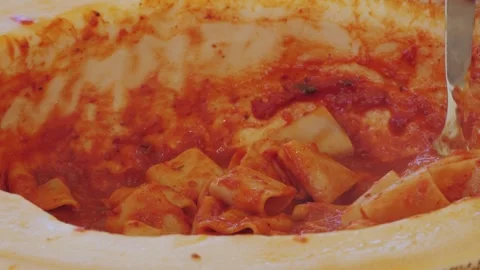Chef stir pasta with boiling tomato sauce in cheese wheel on street, close up Stock Footage 284865340