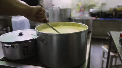 Chef stirring a large pot of hot creamy soup in a professional kitchen, cooking Stock Footage 319191930