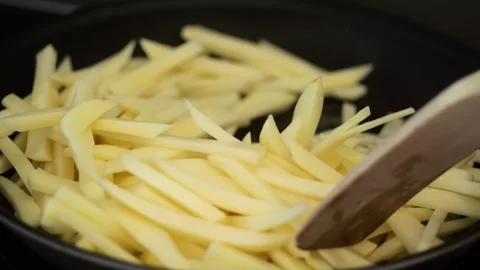 Chef stirring raw potato strips for french fries in a pan Video stock 329199543