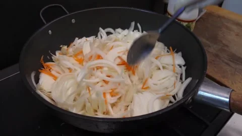 Chef Stirring Sliced Onions and Carrots in Wok Pan Stock Footage 343587917