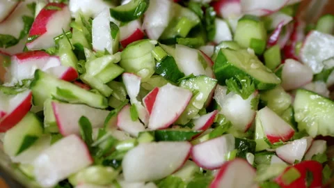 Chef Stirring with a Spoon Fresh Vegetable Salad with Radish, Cucumber, Greens Video stock 197566213
