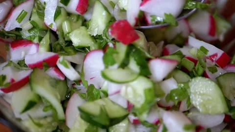 Chef Stirring with a Spoon Fresh Vegetable Salad with Radish, Cucumber, Greens Stock Footage 198463055