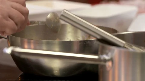 Chef stirring with a spoon in a pan Stock Footage 92074594