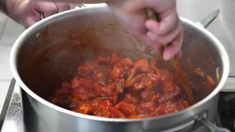 Chef stirring thick meat stew with a wooden spoon in a steel pot close-up. Stock Footage 342150476
