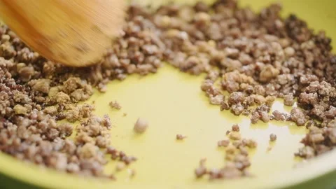 The chef stirs the golden brown cooked beef mince with the spices in the pan. Stock Footage 200810563