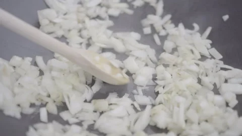 Chef stirs onions in a frying pan with a wooden spoon Stock Footage 266797954