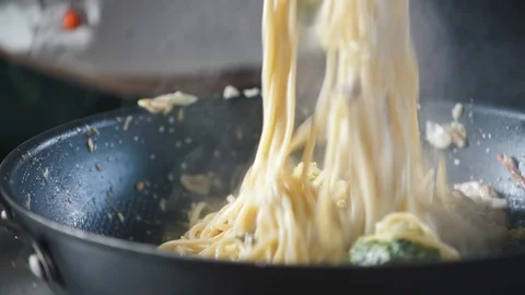 Chef stirs ready-made spaghetti pasta in a pan in a restaurant kitchen. Stock-Footage 124710946