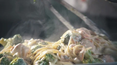 Chef stirs ready-made spaghetti pasta in a pan in a restaurant kitchen. 스톡 동영상 124711070