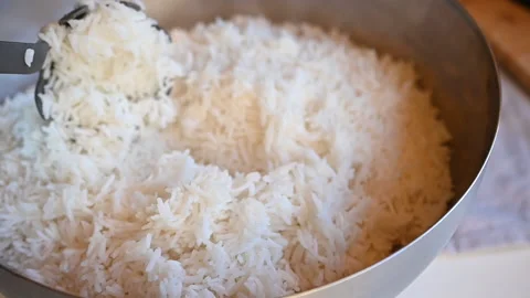 The chef stirs the rice in the pan with a spoon Stock Footage 169989514