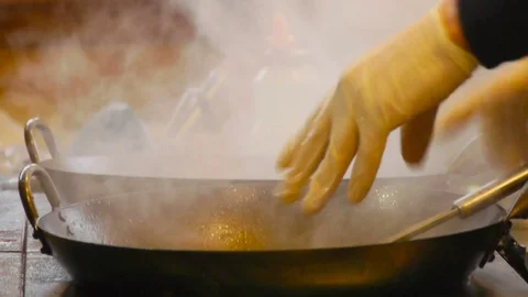 The chef stirs vegetables in a frying pan wok with a wooden spatula Stock-Footage 84252277