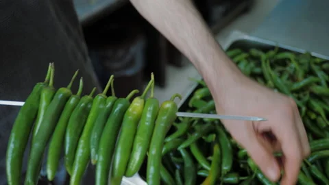 Chef stringing pepper pods on skewer for grilling on bbq at kitchen Stock-Footage 219497746