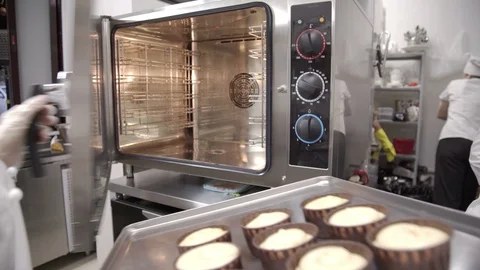Chef take baking tray with cupcakes into oven. Raw cake on baking tray Stock-Footage 96140946