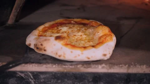 Chef takes cooked thick pizza with baked golden cheese crust Video stock 132126140