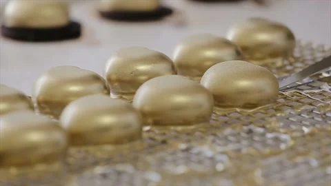 Chef takes one of lots heart shaped cakes with gold color edible coating Vídeo Stock 134681341