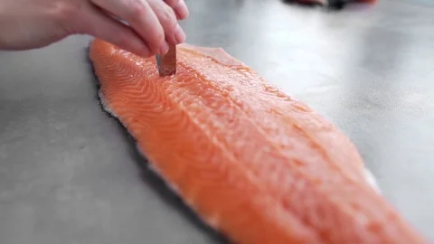 Chef takes out bones from the salmon fillet, cutting fish, dishes with fish Stock Footage 74050554
