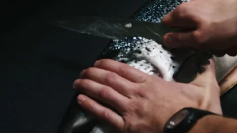 Chef takes out bones from the salmon fillet, cutting fish on slices for cooking Stock Footage 99226690