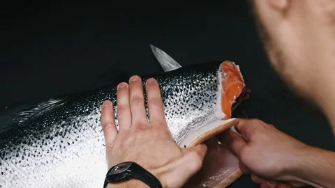 Chef takes out bones from the salmon fillet, cutting fish on slices for cooking Stock Footage 99227360