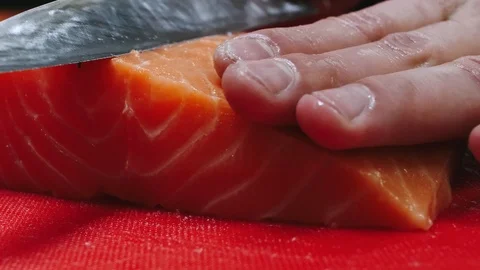 Chef takes out bones from the salmon fillet, cutting fish on slices for cooking Stock Footage 99232857