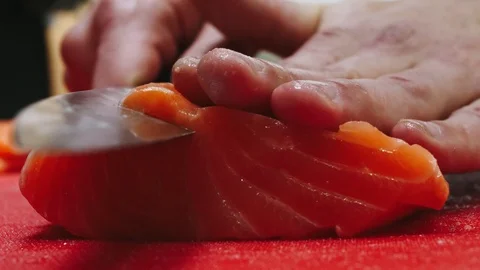 Chef takes out bones from the salmon fillet, cutting fish on slices for cooking Stock Footage 99233621