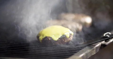 Chef takes patty cheese for burger 4k video. Cheeseburger barbecue charcoal oven Stock Footage 70007048
