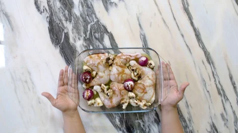A chef takes a tray filled with raw chicken legs and vegetables to be grilled Video stock 122103045