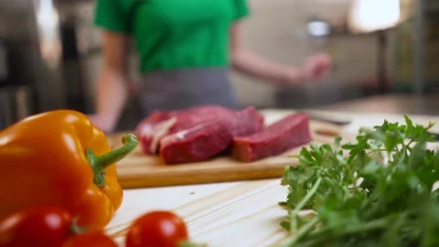 The chef takes a tray of fresh beef steaks from the wooden table. There are Stock Footage 189191782