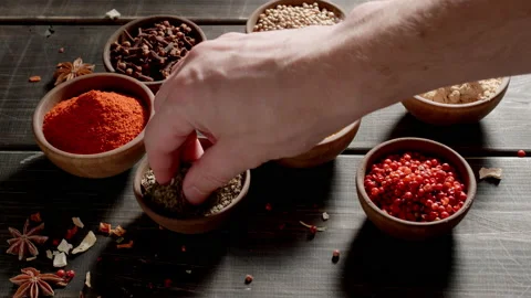 Chef taking dry herbs by hand. Spices and herbs on a table. Видео 144415946