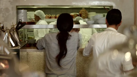 Chef taking order from waitress at kitchen counter. Stock Footage 64118140