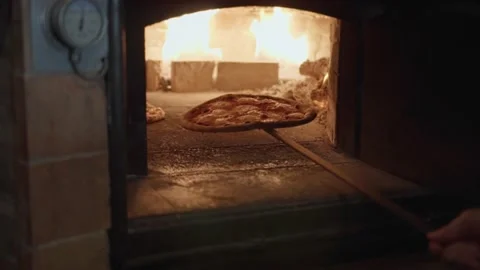 Chef is taking out ready tasty pizza out of an old oven. Video stock 143475747