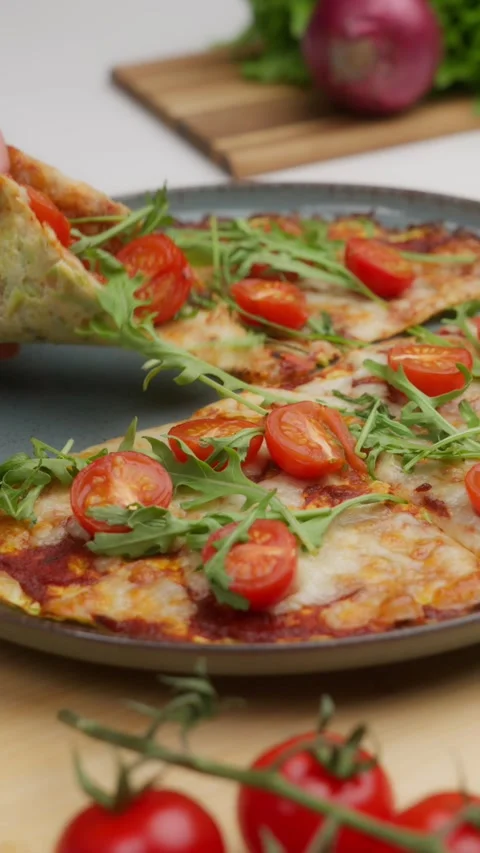 Chef taking slice of zucchini pizza with rocket and cherry tomatoes Stock Footage 310951453