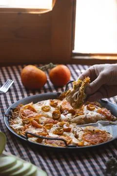 Chef taking slice of zucchini pizza with tomatoes and onions Stock Photos