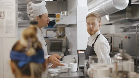 Chef talking to waiter in a commercial kitchen. Stock Footage 125049876